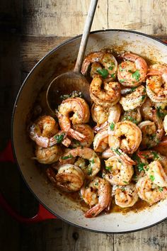 a pan filled with cooked shrimp and garnished with parsley