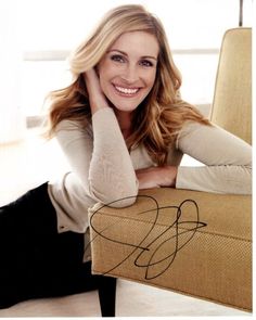 a woman sitting on top of a yellow chair next to a white wall and floor