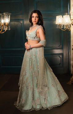 This sea green lehenga features hand embroidered 3D flowers throughout along with sequin,crystal, pearl and cutdana embroidery. It is paired with a matching V neck blouse with tassel and shoulder cap detailing, including an embroidered dupatta.From Isa by Dolly Wahal's Fiori collection.DELIVERY TIMEPlease allow 8-12 weeks for your outfit to arrive.FABRIC DETAILSNetProfessional cleaning only. Green Embellished Traditional Wear For Reception, Embellished Green Traditional Wear For Reception, Elegant Pista Green Organza Choli, Designer Embellished Pista Green Choli, Embellished Pista Green Choli For Designer Wear, Bollywood Style Embellished Pista Green Choli, Festive Green Hand Embellished Sets, Designer Embellished Green Lehenga, Pista Green Embellished Semi-stitched Lehenga