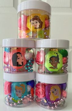 four plastic containers with princess faces on them