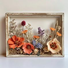 an old frame with dried flowers in it