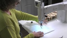 a woman is using a sewing machine to sew something