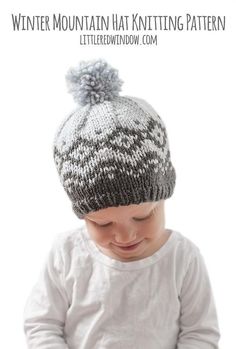 a baby wearing a knitted hat with a pom