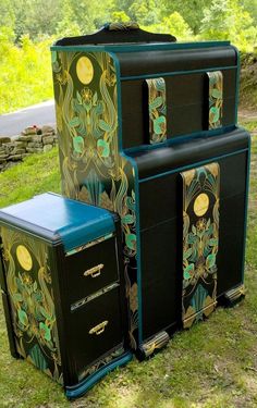 three black and gold painted chests sitting in the grass