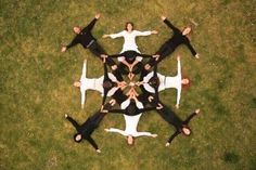 a group of people standing in the middle of a circle on top of green grass