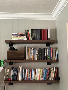 bookshelves with various types of books on them in the corner of a room