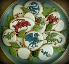 decorated cookies in the shape of animals and leaves on a blue plate with green trim