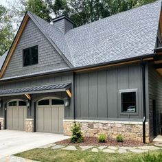 a large gray house with two garages