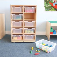 a toy storage unit with plastic bins and toys on the floor next to it