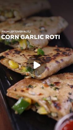 corn garlic roti on a black plate with ketchup and mustard in the background