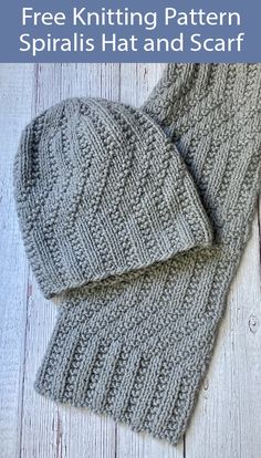 a pair of gray knitted mittens laying on top of a wooden floor next to each other