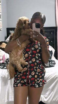 a woman taking a selfie with her cell phone while she is holding a dog