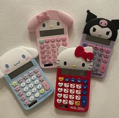 three cell phones with hello kitty on them and a calculator in the middle