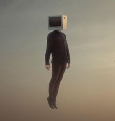 a man is floating in the air with a computer monitor on top of his head