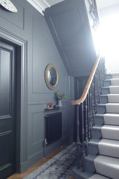 the stairs in this house have been painted dark blue and are lined with gray carpet