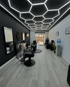 a salon with black chairs and lights on the ceiling