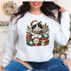 Get cozy this holiday season with our adorable Tuxedo Cat Christmas sweatshirt! Featuring a festive black and white cat in a holiday sweater, surrounded by Christmas ornaments, gifts, and a warm cup of cheer, this sweatshirt is the perfect way to celebrate the season in style. Ideal for dog lovers and anyone who can't resist a cute and cozy holiday vibe! Product Features: * Comfort First: Crafted from a cozy 50/50 cotton-polyester blend, ensuring warmth and softness. * Durable Build: Double-need White Cat Design Top For Winter, White Winter Top With Cat Design, Cute Cat Design Top For Winter, Cute Winter Tops With Cat Design, White Cat Print Top For Winter, Cute Cat Design Tops For Winter, Crew Neck Top With Cat Design As Gift, Crew Neck Top With Cat Design For Gift, Cute Cat Design Winter Tops