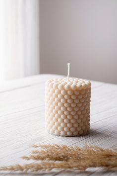 a white candle sitting on top of a wooden table