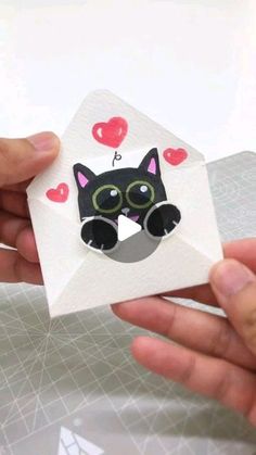 someone is holding an origami cat with glasses on it's face in their hand