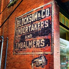 an old sign on the side of a building that says blockson & co undertakers and imbalms