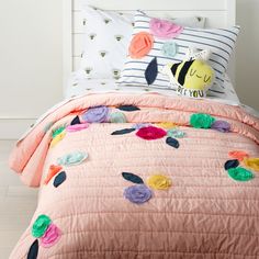 a bed with pink sheets and pillows on it