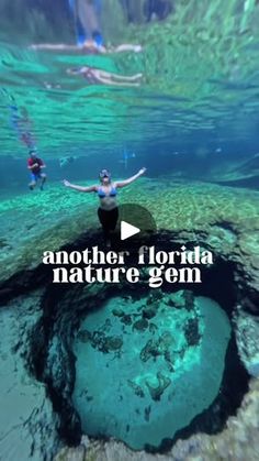 a woman standing on top of a large hole in the ocean with her arms outstretched