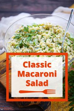 a glass bowl filled with macaroni salad on top of a wooden cutting board