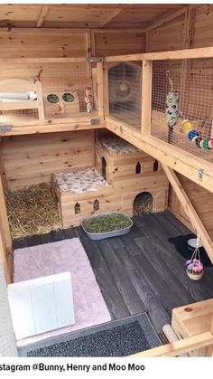 the inside of a wooden rabbit house with several cages and other items on display in it