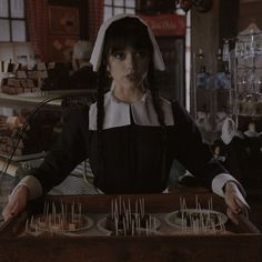 a woman in black and white dress holding tray with food on it