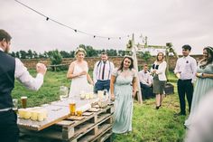 a group of people standing around a table with drinks