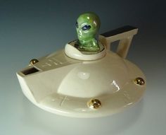 a green alien sitting on top of a white saucer