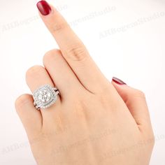 a woman's hand with a diamond ring on her finger and red nail polish