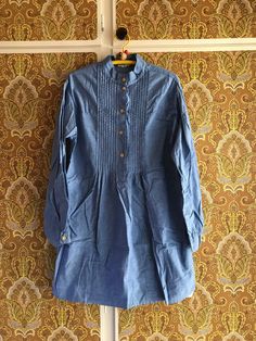 This is a shirt / tunic from Finnish company Marimekko. The fabric is very similar to nurse dresses from the same time. Blue with crispy structure. Nice details. 100% cotton. Size 36, 8, fits X Small - Small. It is from the late 1960s or 1970s. Very good condition, just needs some ironing. Don't hesitate to ask for more details. ♪♫♬ Cotton Tunic Blouse With Buttons, Cotton Tops With Pintucks For Daywear, Casual Cotton Kurta With Placket, Cotton Long Sleeve Blouse With Pintucks, Indigo Cotton Dress With Buttons, Spring Cotton Kurta With Pintucks, Cotton Workwear Tops With Pintucks, Cotton Blouse With Pintucks For Work, Spring Long Sleeve Kurta With Pintucks