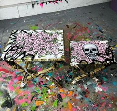 two tables covered in pink roses and skulls on top of paint splattered floor