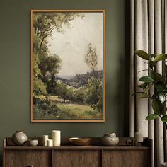 a painting hanging on the wall next to a wooden cabinet with candles and vases