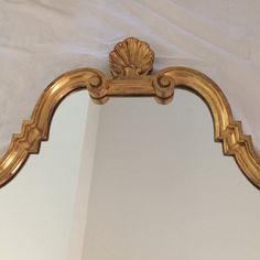 an ornate gold framed mirror hanging on the wall