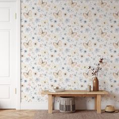 a wooden table sitting in front of a floral wallpaper