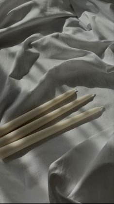 two chopsticks laying on top of a white sheet covered in sheets and blankets