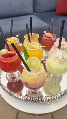 a tray filled with different types of drinks on top of a table next to a couch