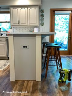 a kitchen island with two stools next to it