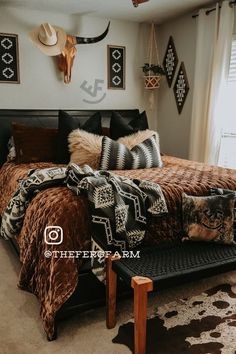 a bed room with a neatly made bed and animal heads on the wall above it