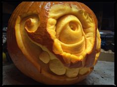 a pumpkin carved to look like a face with spirals and holes in the center