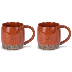 two orange coffee mugs sitting side by side on a white surface with speckled edges