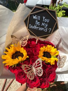 a bouquet of sunflowers and roses with a sign that says will you be my girlfriend?