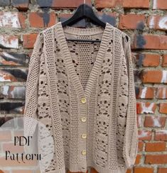 a cardigan sweater hanging on a brick wall