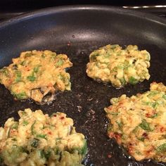 four patties are cooking in a pan on the stove top, ready to be cooked