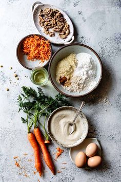 an assortment of food including carrots, eggs and other ingredients on a counter top