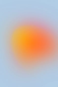 an orange and yellow blurry circle on a blue sky with no clouds in sight