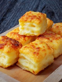 four cheesy biscuits on a wooden cutting board