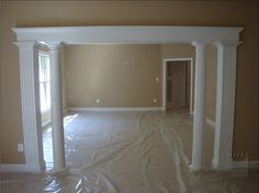 an empty living room with white columns and paint on the walls in preparation for remodeling